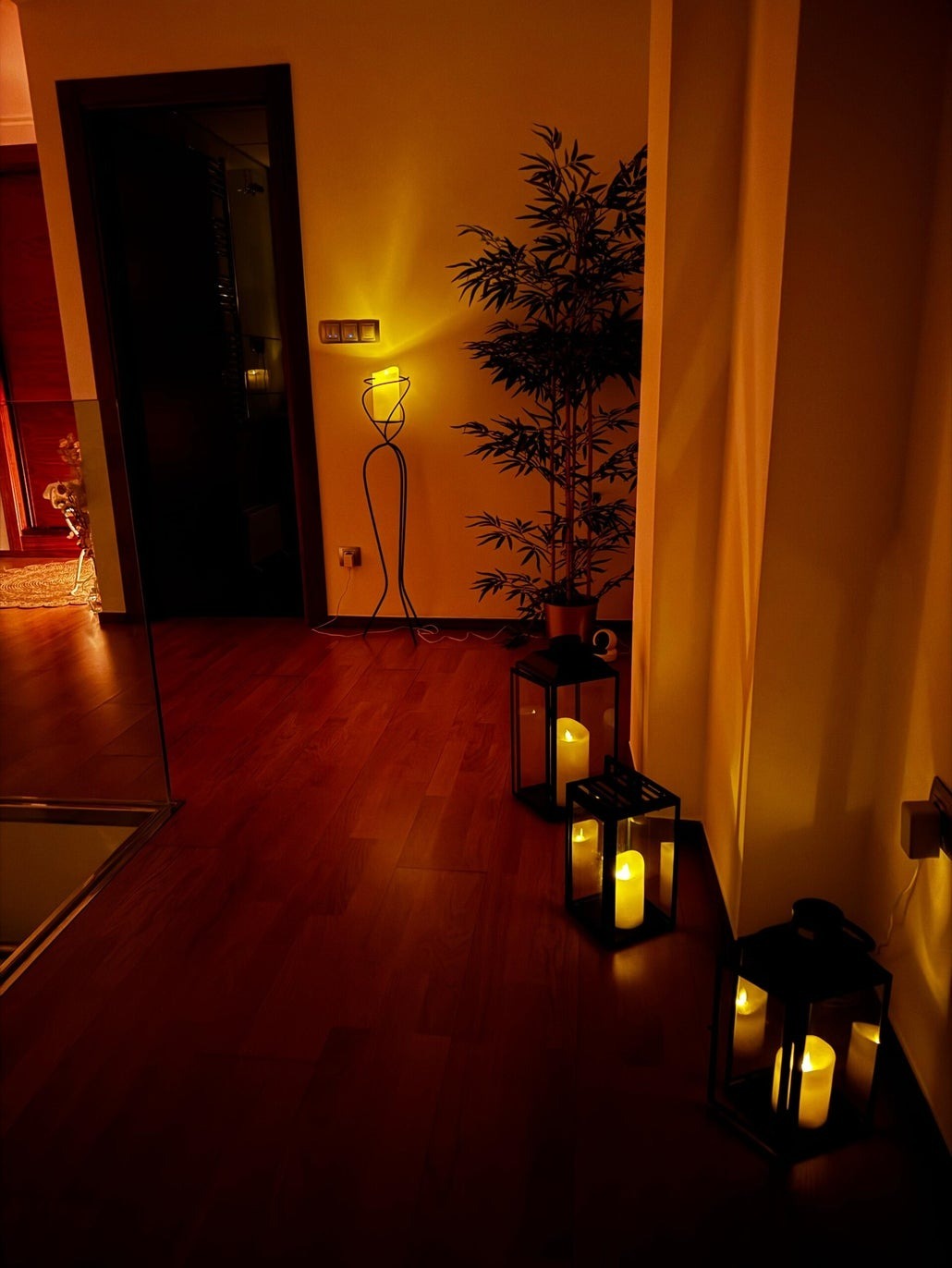 Faroles con velas encendidas sobre suelo de madera en Sofía Masajes, Murcia