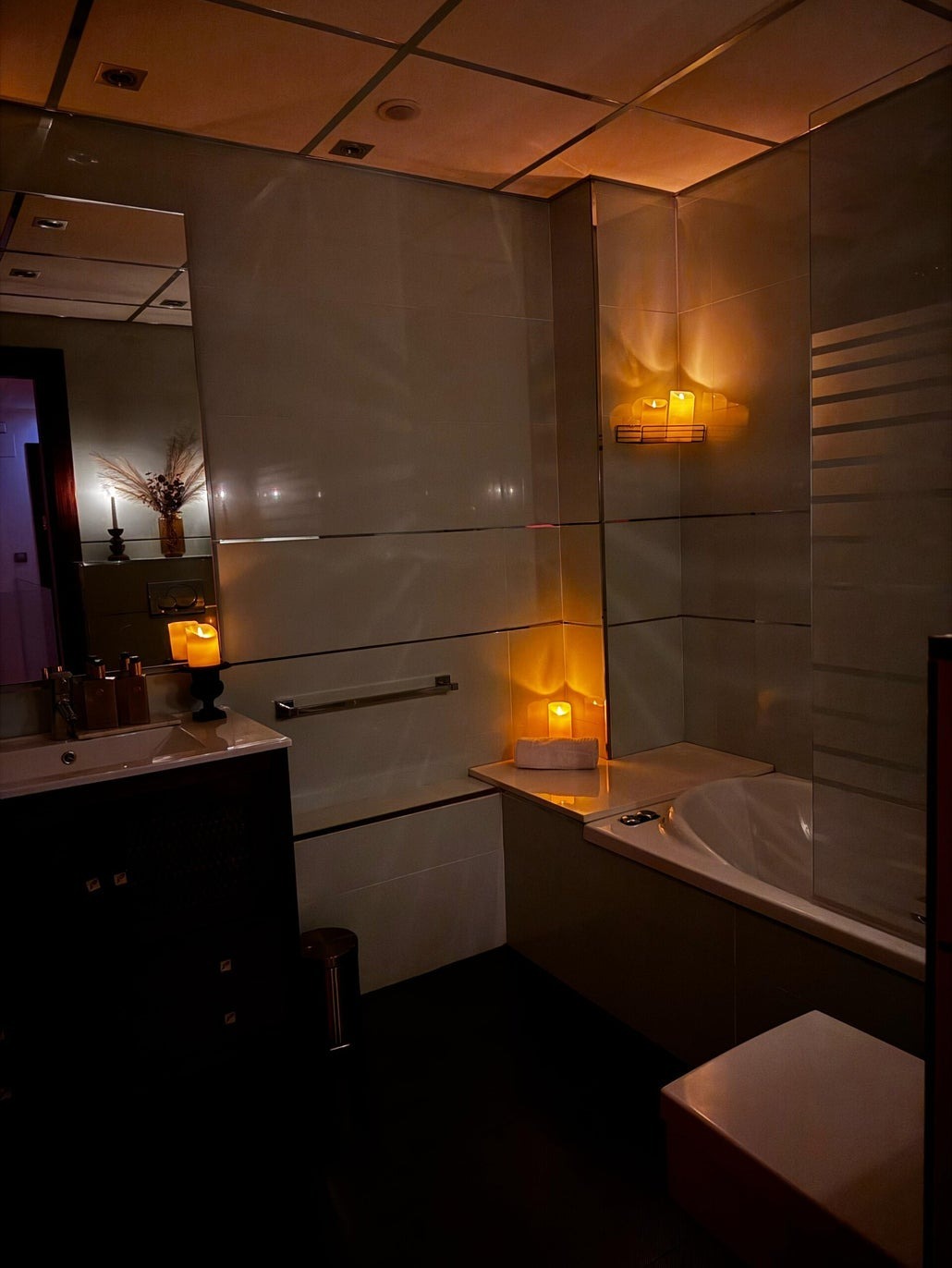 Baño con ducha amplia y bañera a la luz de las velas