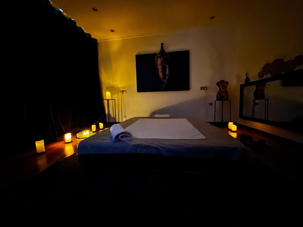 Sala de masaje de Sofía Masajes en Murcia, con camilla baja y una hilera de velas encendidas